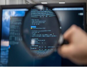 An ethical hacker from Google's red team inspecting a computer screen using a magnifying glass.